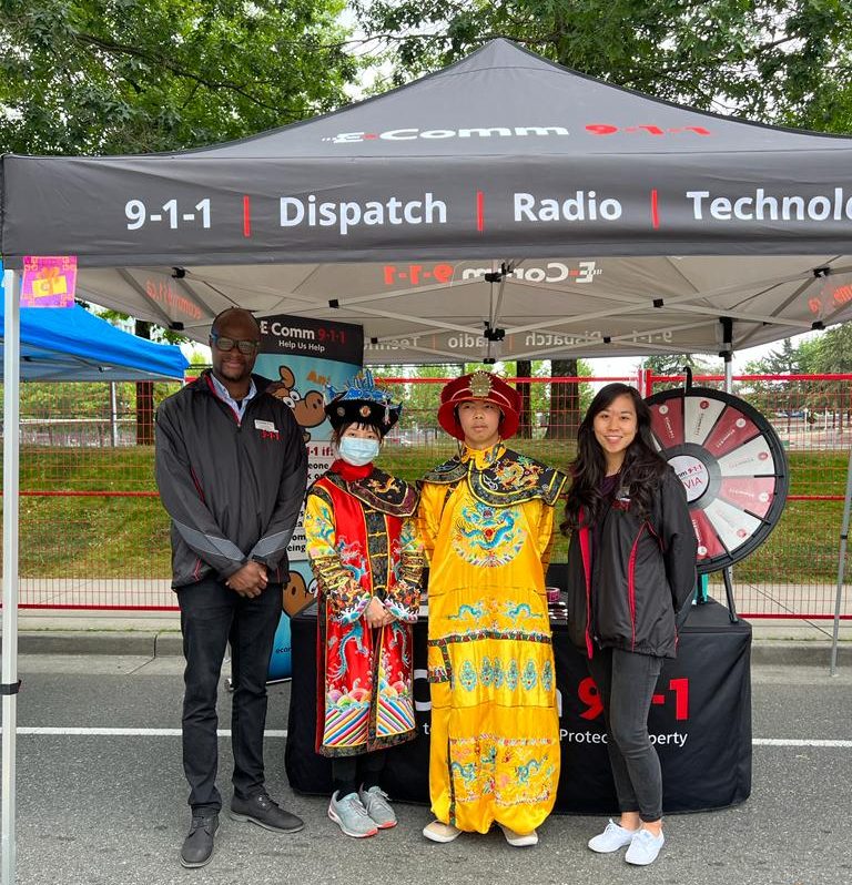 Communications Specialists Tona Aboaba and Dolly Loi posing with festival attendees in traditional Chinese attire at Chinatown Festival in Vancouver on July 16