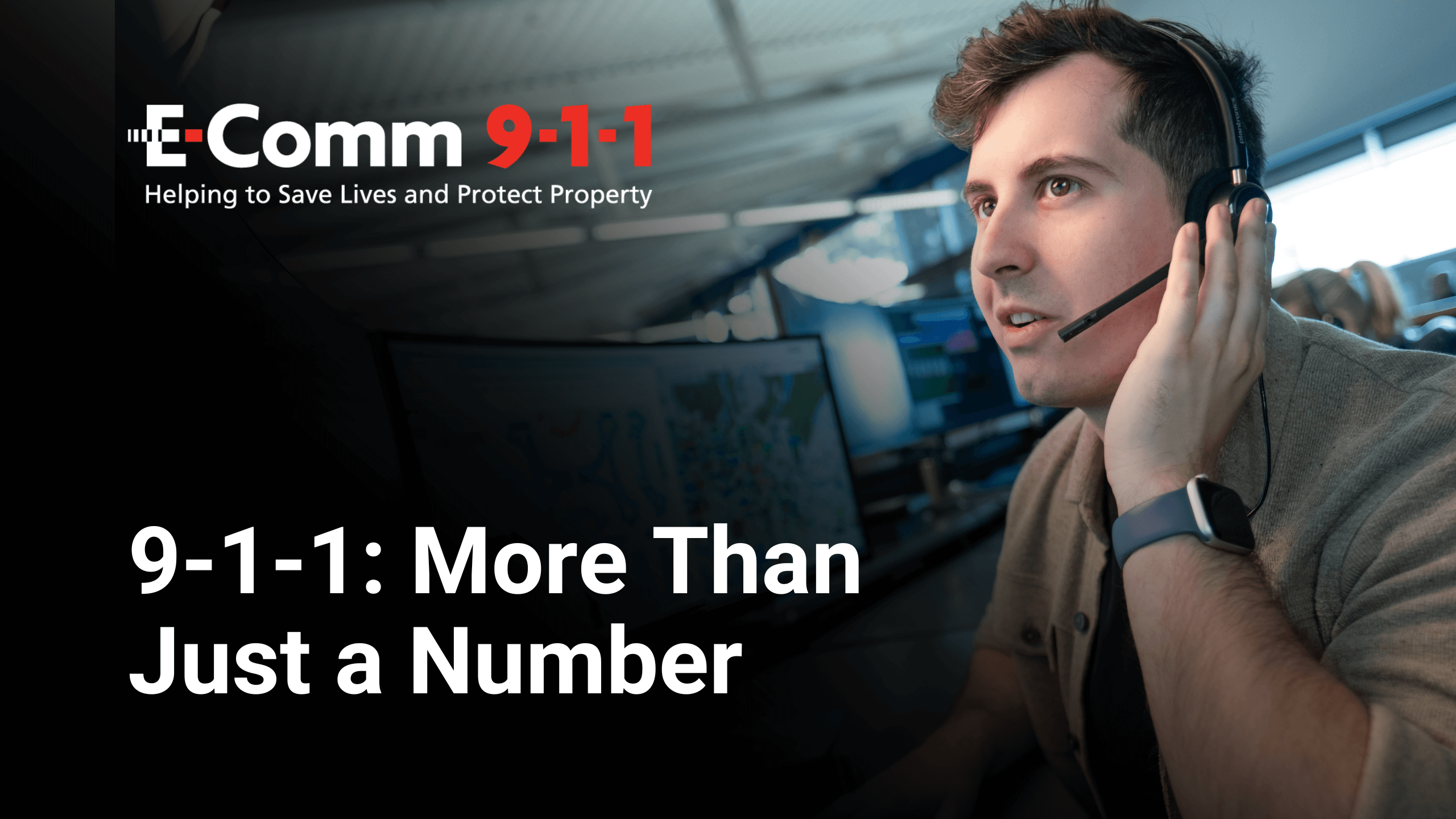 Male call taker sitting in front of a computer holding a headset to his ear.